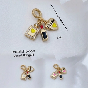 Detail von 18K vergoldeten Parfüm- und Lippenstiftanhängern mit Zirkonia-Besatz
