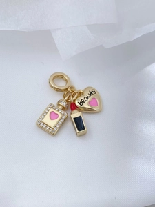 Detail eines 18K vergoldeten Anhängersets mit Lippenstift und Herzanhänger-Charms