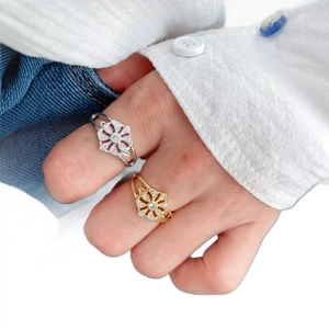 Elegante gold- und silberne Blumenringe mit Zirkon-Mikrofassung am Handdetail