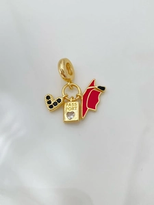 Macro detail of gold passport and black heart charms for luxury beaded necklaces