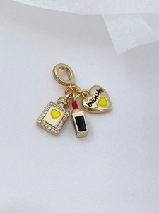 Detail von 18K vergoldeten Anhängern: Parfümflasche, Lippenstift und 'beauty' Herz-Anhänger