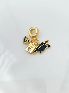 Close-up of 18K gold pendant with black zircon heart and passport engraved charm