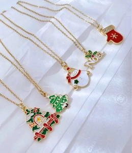 Detalle macro de colgantes navideños de esmalte con muñeco de nieve y árbol de Navidad