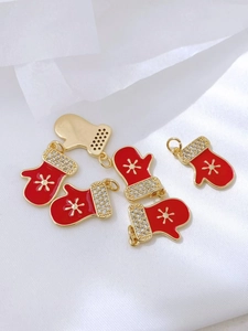 Detalle de colgante de guante navideño esmaltado rojo con copo de nieve y circonitas finas