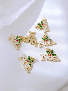 Detalle del colgante navideño Noel dorado con esmalte blanco y acebo decorativo