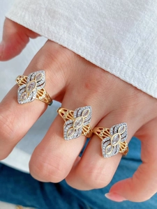 Dettaglio ravvicinato di anelli placcati in oro 18K con pietre marquise e pavé di diamanti