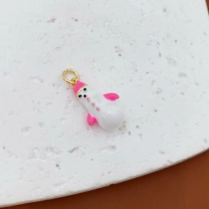 Cute snowman pendant with pink hat and gold ring on a textured stone for winter