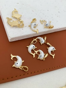 Detail van 18K vergulde dolfijn hangers met inleg van natuurlijke parelmoer schelp