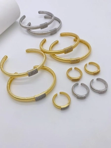 Nahaufnahme von gold-silber gerippten Armreifen und Ring-Sets mit Zirkonia-Steinen