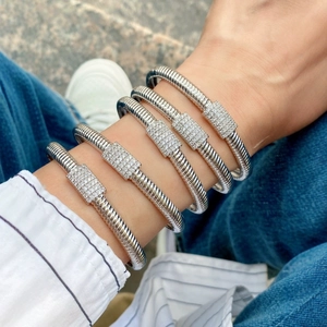 Nahaufnahme von silberfarbenen Tubogas-Armbändern mit pavé-gefassten Zirkonia-Elementen
