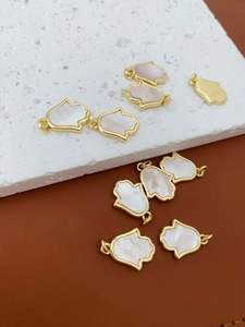 Detail van de 18K vergulde Hamsa-hanger met witte parelmoer inleg voor doe-het-zelf sieraden
