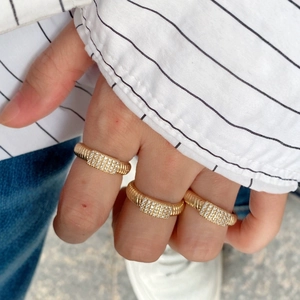 Dreiteiliges goldenes Spiralring-Set mit Zirkonia-Mikropflaster auf der Hand des Modells