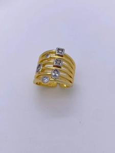 Détail macro d'une bague dorée multi-rangs avec cristaux variés et anneau réglable