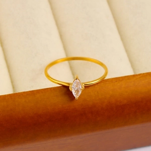 Macro detail of 18K gold plated marquise zircon ring resting on a jewelry box edge