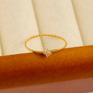 Close-up of 18K gold plated twisted rope ring with a sparkling square zircon inlay