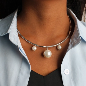 Détail d'un collier argenté style bambou avec trois pendentifs perles sur un mannequin