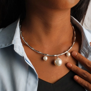 Collier style bambou en argent avec trois pendentifs en perles blanches porté au cou