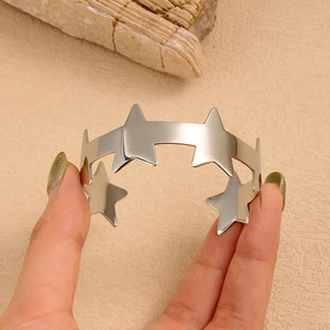Detail van de zilveren roestvrijstalen C-armband met gepolijste holle stermotieven