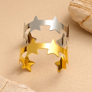 Detailweergave van goud- en zilverkleurige C-vormige armbanden met uitgesneden sterpatronen