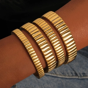 Close-up of four-piece gold elastic bracelet set with a sleek industrial watch band design