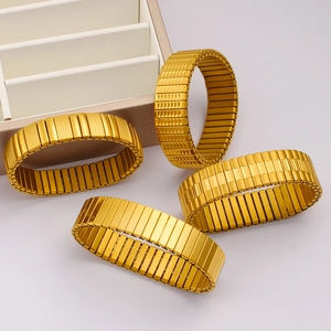 Detailed macro shot of golden stainless steel elastic bracelets with embossed textures