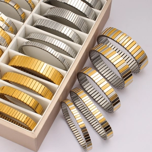 Detailed close-up of elastic stainless steel watch-band style bracelets in gold and silver