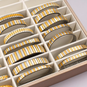 Macro detail of elastic stainless steel watch bands in gold and silver mixed tones