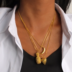 Three-layer gold necklace featuring pineapple, crescent moon and heart pendants