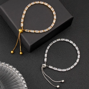 Detail of adjustable gold and silver bracelets with square-cut cubic zirconia crystals