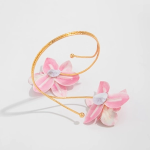 Gouden spiraalarmband met roze stoffen bloemen voor een bohemien zomerse uitstraling