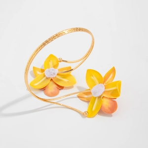 Detail van de gouden bloemenarmband met getextureerd metaal en realistische bloemen