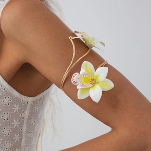 Detail van bloemige armband met witte orchideeën op een gouden spiraalband