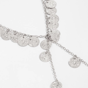 Detail van zilveren ketting met reliëf muntbedeltjes en verfijnde metalen gravures