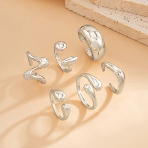 Macro view of 6-piece silver irregular geometric open rings with liquid metal texture