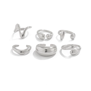Detailed macro view of minimalist silver liquid metal ripple and water drop ring set