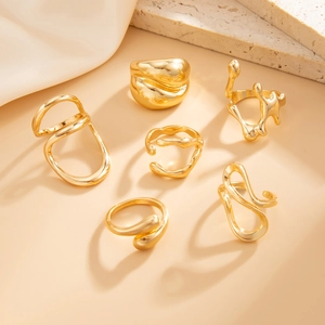 Collection of six liquid gold rings with irregular lava texture and mirror finish