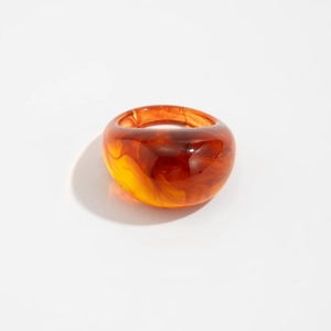 Detailed macro view of the amber translucent resin ring with marbled tortoise shell texture