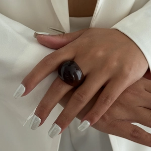 Deep brown translucent resin ring with minimalist dome design worn on a finger