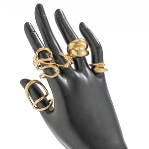 Detailed macro view of four-piece gold irregular liquid metal rings on black display