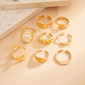 Detailed view of 8-piece gold metal ring set featuring a unique pearl cage design on stone