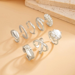 Detailed view of 7-piece silver ring set featuring baroque pearl and lava metal texture