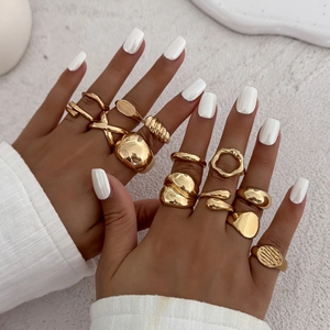 Detail of gold water drop open rings and liquid metal ripple rings on female hand