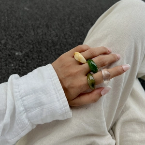 Close-up of translucent colorful resin rings in marble yellow and emerald green tones
