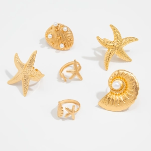 Goldenes Ring-Set im Ozean-Stil mit Seestern- und Muscheldesigns sowie Perlen auf Weiß