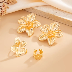 Detaillierte Makroansicht der goldenen Blumen-Ohrstecker mit gebürsteter Metalltextur