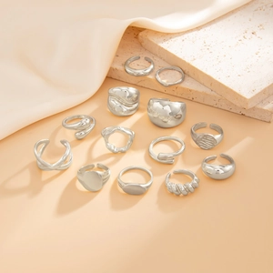Collection of silver minimalist rings with fluid metal and crinkled textures on stone