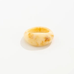 Detailed view of translucent resin ring with amber marble texture on white background