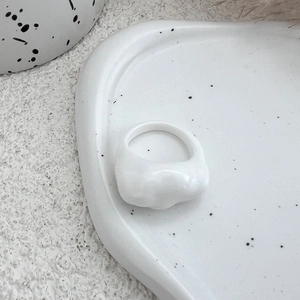 Macro view of white resin ring with irregular wave texture and minimalist art style