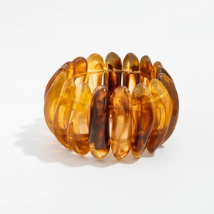 Gros plan du bracelet en résine ambrée montrant la texture marbrée et la brillance