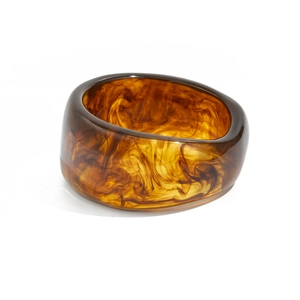 Détail macro d'un bracelet en résine ambrée montrant la texture translucide écaille